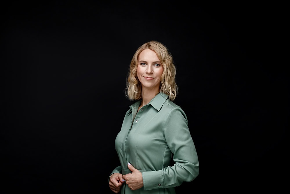 Verslo portretų fotografija studijoje „Subtilūs vizualai“ – profesionalus moters portretas suformuotas tamsiame, formaliame stiliuje.