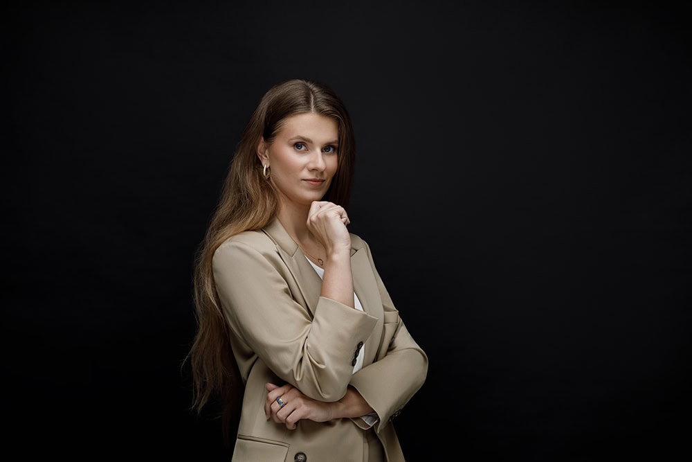 Verslo portretų fotografija studijoje „Subtilūs vizualai“ – profesionalus moters portretas suformuotas tamsiame, formaliame stiliuje.